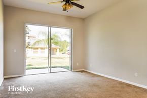 Kissimmee house for rent - an empty living room with sliding glass doors to a yard