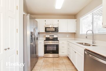 Phoenix house for rent - A kitchen with white cabinets and stainless steel appliances.