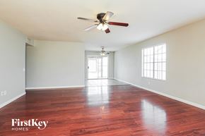 Phoenix house for rent - A spacious room with a ceiling fan and wooden flooring.