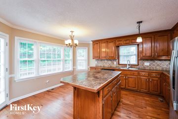 Conyers house for rent - a kitchen with wooden cabinets and a granite counter top