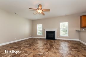 Indian Trail house for rent - a living room with a fireplace and a ceiling fan