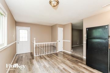 Florissant house for rent - A kitchen area with a black fridge and wooden flooring.