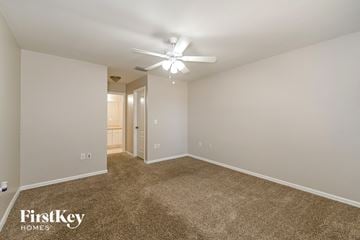 Cape Coral house for rent - a spacious living room with carpet and a ceiling fan