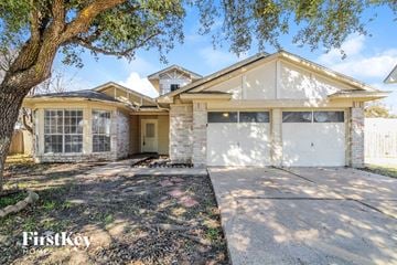 Katy house for rent - a white brick house with a garage and a tree