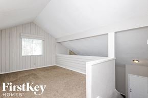 Carrollton house for rent - a small attic bedroom with white walls and a window