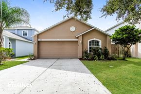 Winter Haven house for rent - a beige house with a driveway and a garage door
