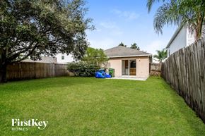 Winter Haven house for rent - a backyard with a house and a yard with grass and a fence