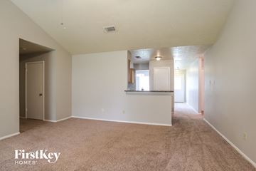 Spring house for rent - a spacious living room with carpet and a kitchen