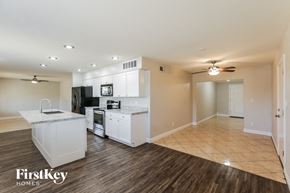 Phoenix house for rent - a kitchen and living room with white cabinets and a counter top