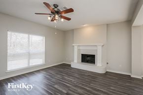Rockwall house for rent - a living room with a fireplace and a ceiling fan
