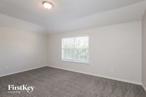 Rockwall house for rent - a bedroom with a carpeted floor and a window