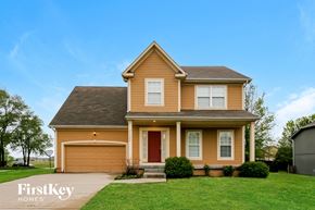 Olathe house for rent - A two-story house with a red door and a garage.