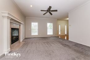 Olathe house for rent - A spacious room with a fireplace and a ceiling fan.