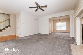 Olathe house for rent - A spacious room with a ceiling fan and a carpeted floor.