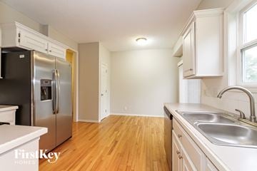 Olathe house for rent - A kitchen with a stainless steel refrigerator and wooden floors.