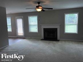 Dacula house for rent - an empty living room with a ceiling fan and a fireplace
