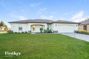Cape Coral house for rent - a white house with a lawn in front of it