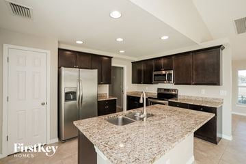 Cape Coral house for rent - a kitchen with granite counter tops and stainless steel appliances