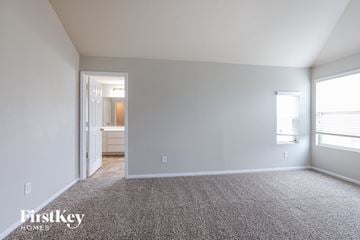 Humble house for rent - a living room with carpet and a door to a bathroom