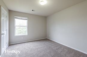 Humble house for rent - a bedroom with white carpet and a window