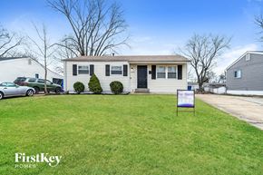 Florissant house for rent - a white house with a purple sign in front of it