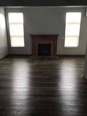 Grove City house for rent - an empty living room with wood floors and a fireplace