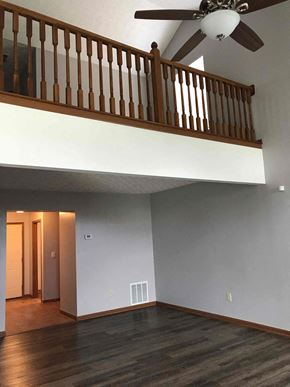 Grove City house for rent - an empty living room with a ceiling fan and a staircase