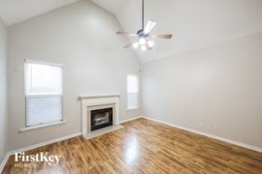 Moody house for rent - A spacious room with a fireplace and a ceiling fan.