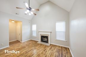 Moody house for rent - A spacious room with a fireplace and a ceiling fan.
