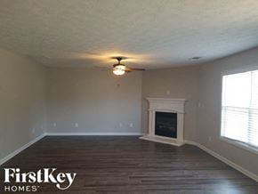 Mcdonough house for rent - A room with a fireplace and a ceiling fan.