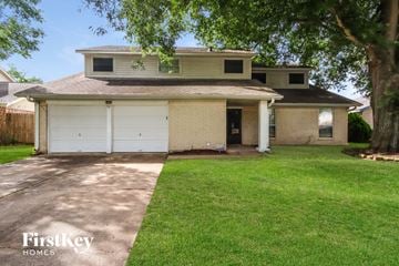 Katy house for rent - a white brick house with a white garage door