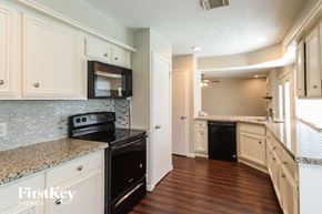 Katy house for rent - a renovated kitchen with white cabinets and black appliances
