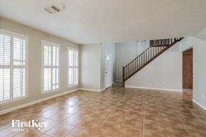 Katy house for rent - A spacious room with a staircase and tiled flooring.