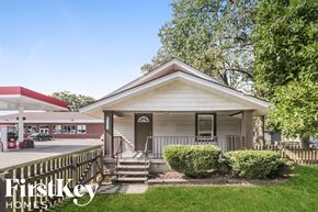 Indianapolis house for rent - a small white house with a porch and a gas station
