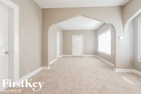 Indianapolis house for rent - an empty living room with a white door and a carpeted floor