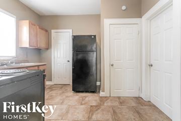 Indianapolis house for rent - a kitchen with a black refrigerator and white doors