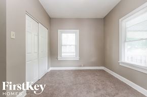 Indianapolis house for rent - a bedroom with a carpeted floor and two windows