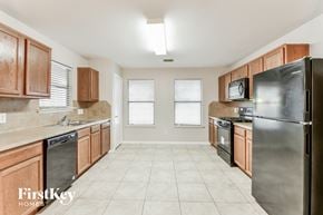 Humble house for rent - a kitchen with wooden cabinets and stainless steel appliances