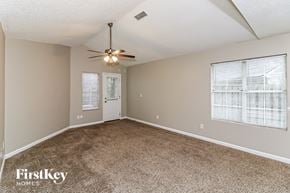 Marietta house for rent - A room with a carpeted floor, a ceiling fan, and two windows with blinds.