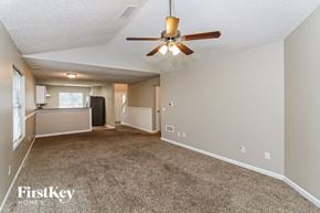 Marietta house for rent - A spacious room with a ceiling fan and carpeted floor.