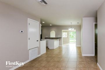 Margate house for rent - A spacious kitchen and living room with white cabinets and a tiled floor.