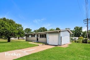 Florissant house for rent - a small white house with a lawn and a driveway