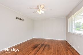 Florissant house for rent - a living room with wood floors and a ceiling fan