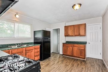 Florissant house for rent - a kitchen with black appliances and wooden cabinets