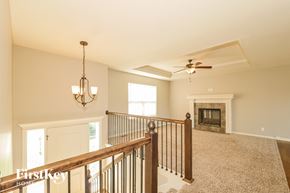 Peculiar house for rent - A spacious living room with a fireplace and a fan.