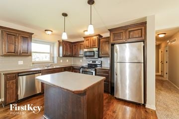 Peculiar house for rent - A kitchen with wooden cabinets and a stainless steel refrigerator.