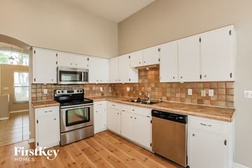Brandon house for rent - A kitchen with white cabinets and a tile backsplash.
