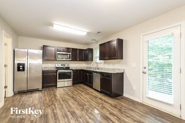 Greensboro house for rent - A kitchen with wooden floors and a refrigerator with a water dispenser.
