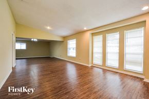 Orlando house for rent - an empty living room with wood flooring and large windows