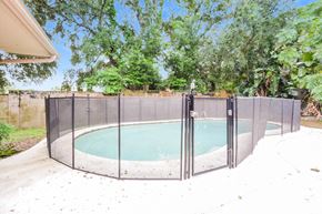 Orlando house for rent - an enclosed pool with a fence around it in a backyard